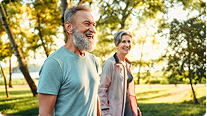 Older couple walking in sunny park