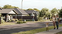 Family walking along suburban street at sunset
